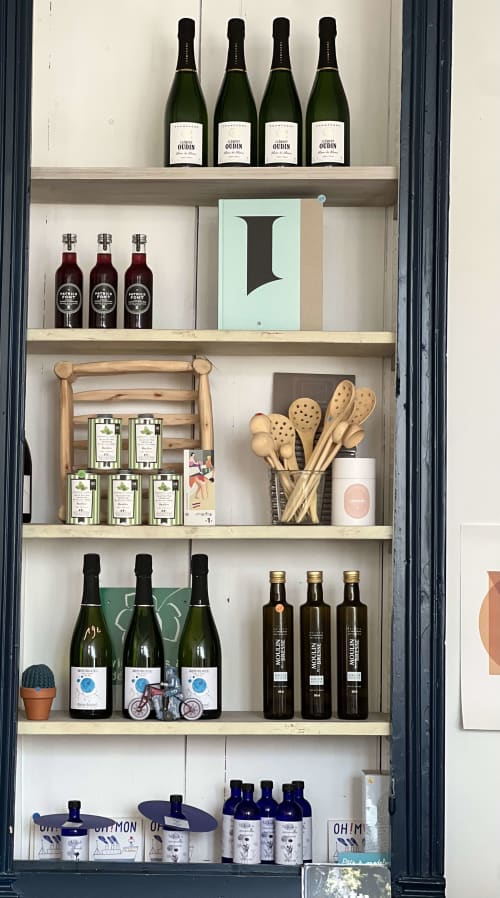 Vitrine boutique à La Maison d'Ambronay avec bouteilles de vin, produits gastronomiques et ustensiles de cuisine