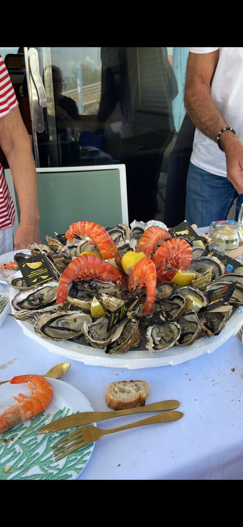 Plateau de fruits de mer frais avec huîtres, crevettes et citron, expérience gastronomique en bord de plage à Cap d'Agde