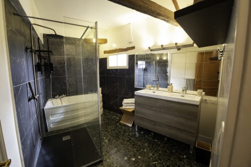Salle de bain moderne avec carrelage en marbre noir, douche vitrée et meuble-lavabo en bois à la Domaine Chapelle B&B