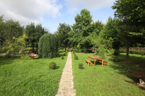 Allée verdoyante du gîte Domaine Chapelle avec table de pique-nique en bois et balançoire à La Chapelle-la-Reine