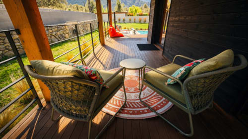 Terrasse de villa moderne avec deux fauteuils en rotin, vue sur les montagnes et la piscine, Corse