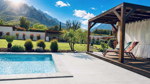 Villa de luxe en Corse avec piscine chauffée, pergola en bois, transats et jardins paysagers avec vue sur les montagnes