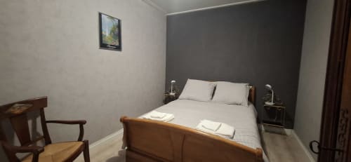 Chambre moderne à l'hôtel Accolade à Châteaudun avec lit en bois, mur accent gris et vue sur la ville