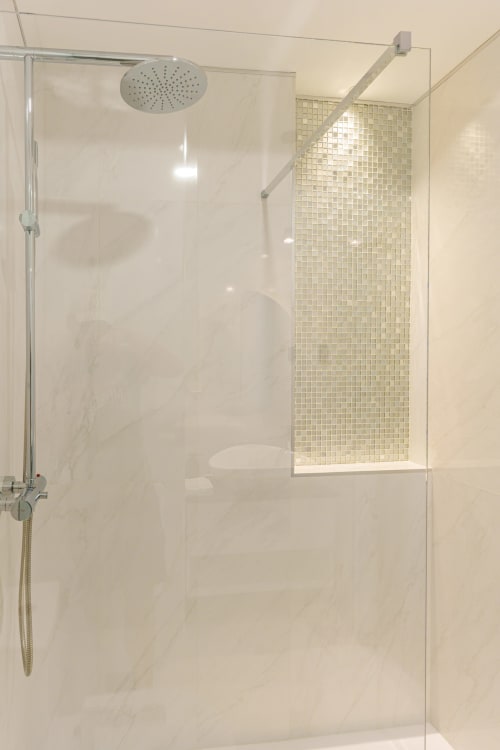 Modern glass shower enclosure with rainfall showerhead at Suites Avenue Lux Apartments in Horta