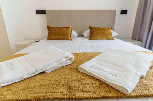 Luxury bedroom at Suites Avenue Lux Apartments in Horta with plush bedding, gold accents, and folded towels