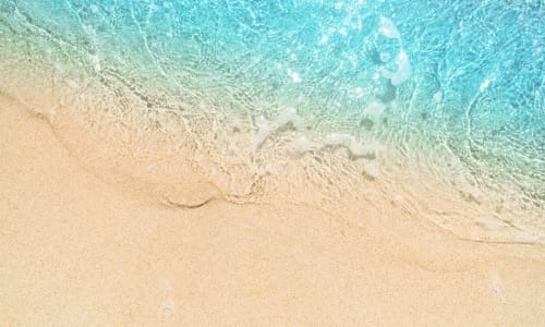 Vagues turquoise s'échouant doucement sur la plage de sable de l'hôtel La Maison de Clementine à Fort-de-France