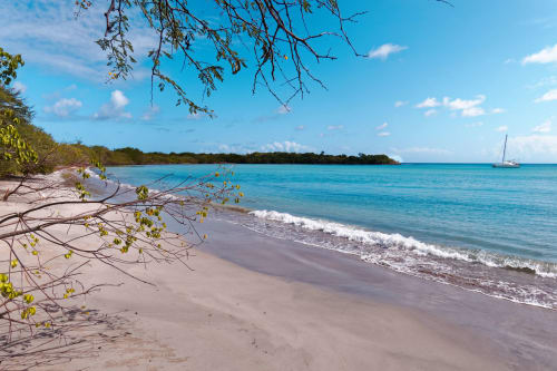 Plage tropicale immaculée aux eaux turquoise, sable blanc et voilier près de Fort-de-France
