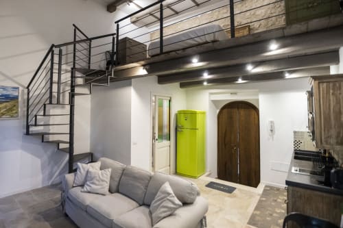 Moerno monolocale a Le Mura Rooms a Norcia con letto a soppalco, divano grigio, frigorifero giallo brillante e open-space