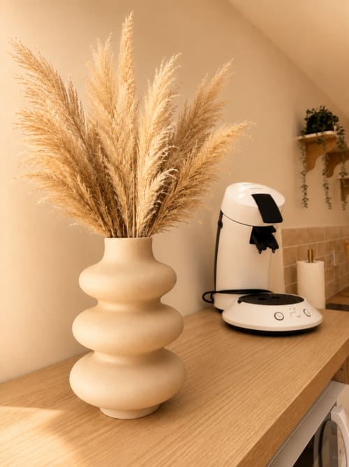 Vase crème avec herbes de la Pampa séchées et distributeur de savon blanc sur bureau en bois à L'Escapade, Le Mans