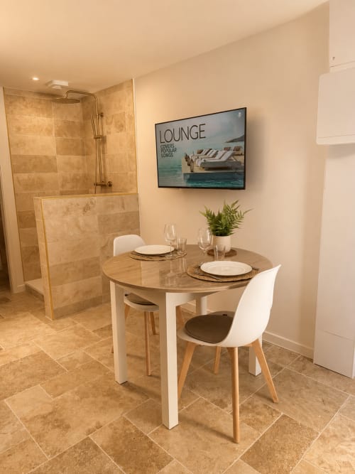 L'Escapade Le Mans : Studio moderne avec table à manger, salle de bain douche et coin salon avec TV