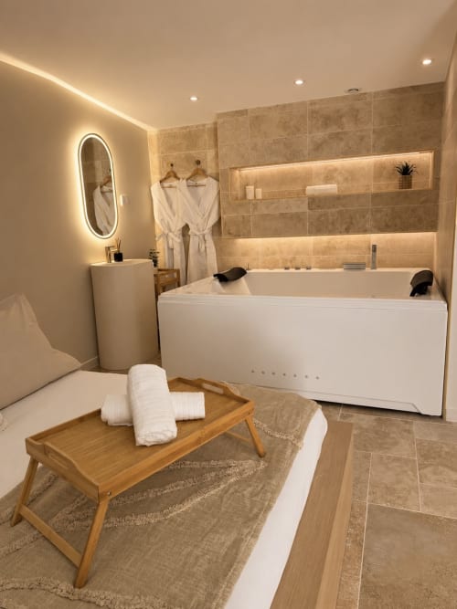 Salle de bains spa luxe à l'hôtel L'Escapade au Mans avec baignoire contemporaine, sèche-serviettes chauffant et éclairage ambiant