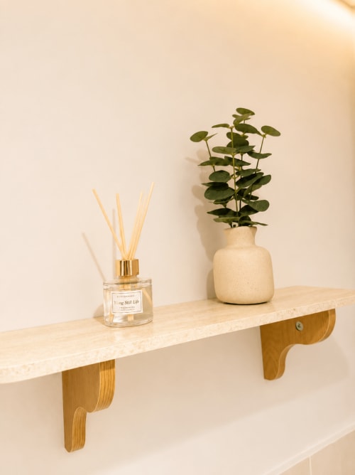 Étagère murale en bois à L'Escapade Le Mans avec diffuseur de roseaux et plant d'eucalyptus en pot