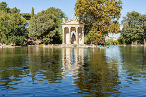 Padiglione in stile classico sul Tevere a Roma, circondato da alberi e volatili acquatici, vicino all'Hotel Ercoli House