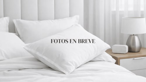 Habitación Doble Estándar del hotel San Poul con ropa de cama blanca, almohadas y lámpara de mesita en España