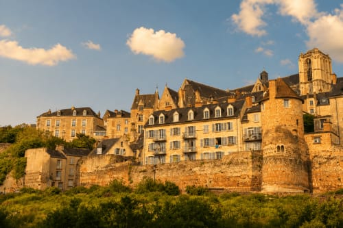 Village médiéval historique aux bâtiments en pierre dorée et clocher dominant Le Mans, France
