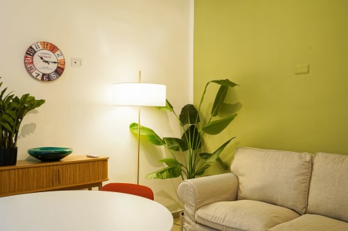 Modern apartment living area at Calaba Decumani in Naples with beige sofa, potted plants, floor lamp, and colorful accent