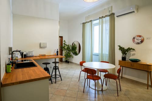 Modern Calaba apartment in Naples with dining area, kitchen counter, and city views through large windows