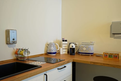 Modern kitchen area at Calaba Decumani apartment in Naples with wooden counters, appliances, and decorative accessories