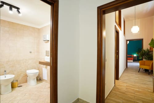 Calaba Decumani apartment hallway with bathroom entrance, wooden doors, and living area view in Naples