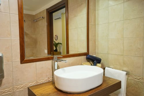 Modern bathroom at Calaba Decumani apartment in Naples with white round sink and wooden vanity