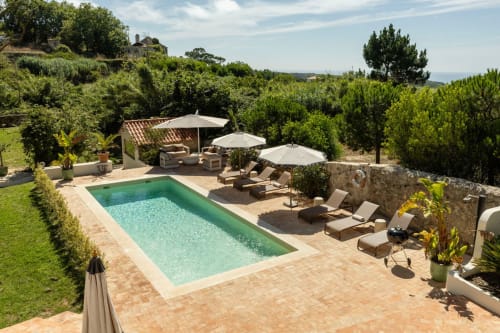 Sea'Ya Villas pool area in Cascais with loungers, umbrellas, and lush gardens overlooking the countryside