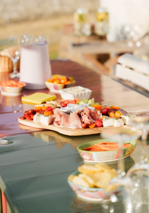 Élégante planche de charcuterie et fromages avec viandes cured et légumes colorés au Hameau de Céline, campagne française