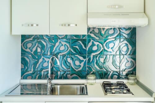 Cucina moderna nell'appartamento Ariè a Procida con piastrelle retro turchese, lavello in acciaio inox e piano cottura a gas