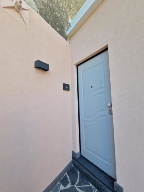 Ingresso all'appartamento Ariè presso Origenes Rooms a Procida con porta azzurra e entrata indipendente