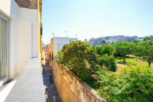 Terrazza con balcone presso Origenes Rooms a Procida: giardino e vista sulla città tra la lussureggiante vegetazione mediterranea