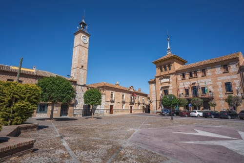 Plaza Mayor de Consuegra con su histórica torre reloj y edificios de piedra, zona del Hostal San Poul