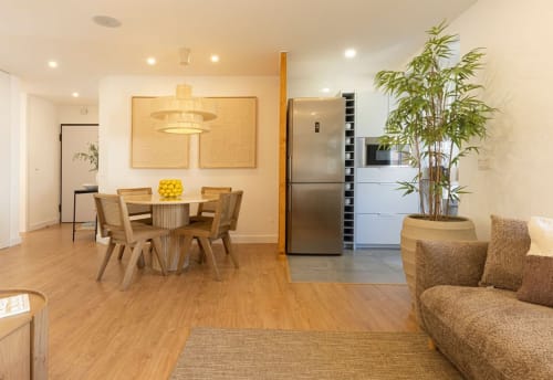 Modern open-plan kitchen and dining area at Sea'Ya Villas Cascais with wooden furniture, stainless steel appliances, and
