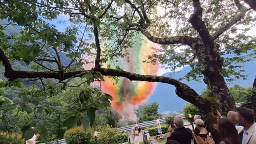 Esplosione di polvere colorata alla celebrazione della Locanda del Sasso sotto un antico albero a Crodo, Italia