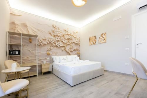 Lussuosa camera king alle Aurum Nolana Suites di Pompeii con letto bianco, decorazioni floreali alle pareti e balcone con vista sulla montagna.