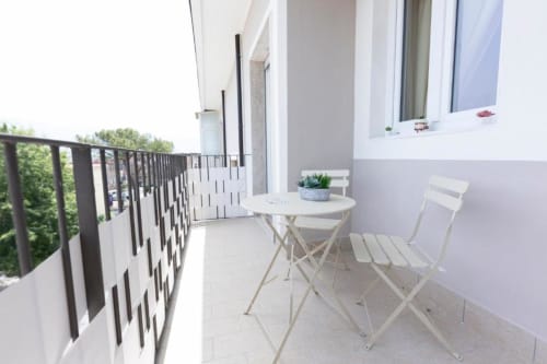 Splendida terrazza alle Aurum Nolana Suites di Pompei con arredamenti bianchi, tavolo rotondo e vista sulla città