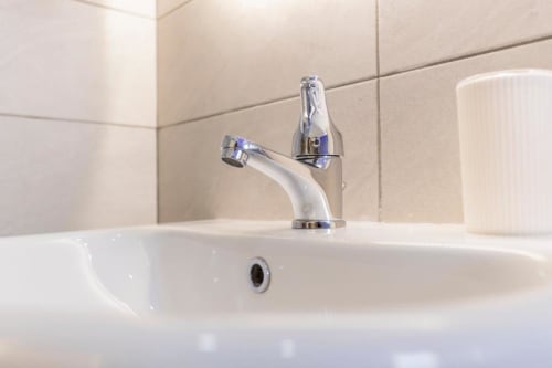 Moderno lavabo da bagno con rubinetto cromato e bacino bianco presso l'Aurum Nolana Suites a Pompei