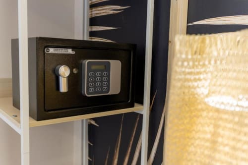 Cassaforte elettronica nera con serratura a tastiera su scaffale in legno nella Deluxe Double Room dell'Aurum Nolana Suites di Pompei