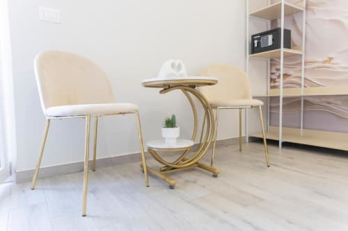 Elegante zona living con poltrone color crema e tavolino dorato presso l'Aurum Nolana Suites di Pompei
