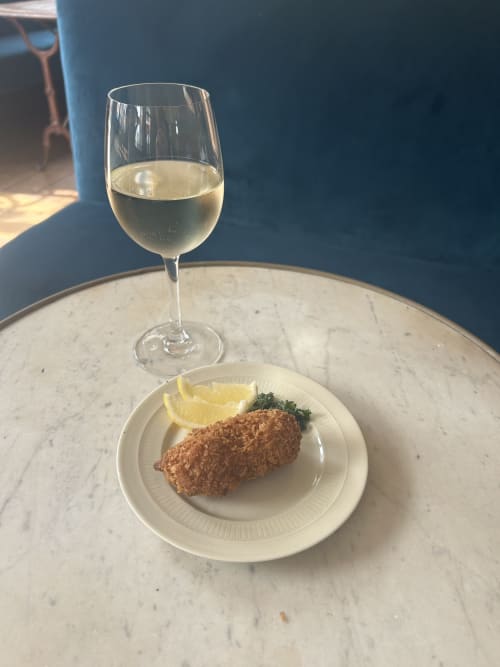 Verre de vin blanc avec fruits de mer panés et citron à l'Hidden Bay Hotel, Cayeux-sur-Mer