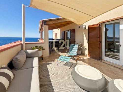 Terrasse bord de mer de l'appartement Pointe Saint-François à L'Île-Rousse avec salon, transats, auvent et