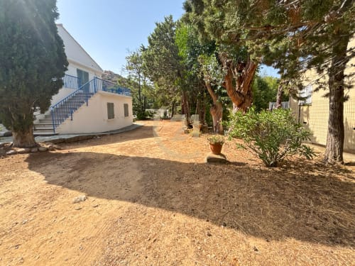 Maison authentique avec jardin à Calvi, Île-Rousse : cour en terre cuite, arbres matures et escalier d'entrée bleu