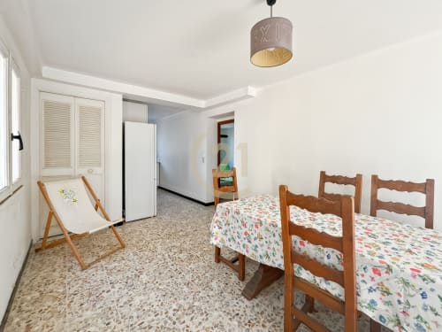 Chambre spacieuse avec deux lits en bois, transat et carrelage en terrazzo dans l'appartement de L'Île-Rousse