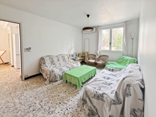 Chambre spacieuse à Calvi avec deux lits, vue sur jardin et mobilier lumineux