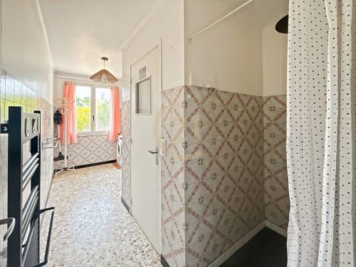 Buanderie moderne avec papiers peints, machines à laver et grandes fenêtres ensoleillées dans l'appartement de Calvi
