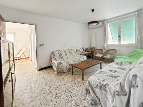 Spacieux séjour d'appartement à Calvi avec lit, canapé, table en bois et vue sur le jardin