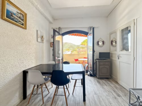 Appartement moderne avec vue mer à L'Île-Rousse, salle à manger ouvrant sur balcon côtier avec vue sur parapentistes