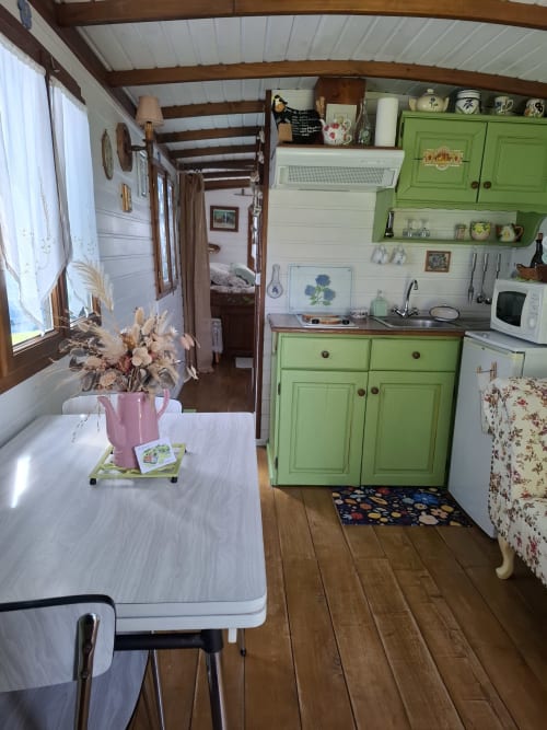 Petite cuisine cosy aux armoires vertes de la maison d'hôtes Les Gravets à Sigalens, France
