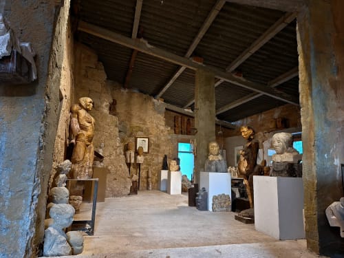 Galería de escultura rústica en Casa Llobera 1792, La Pobla de Cèrvoles, con estatuas de madera sobre pedestales blancos