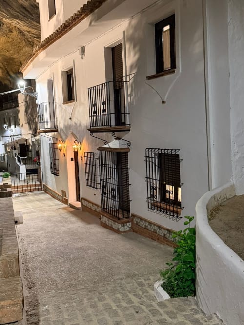 Edificio encalado de Setenil de las Bodegas de noche con balcones y ventanas de hierro negro
