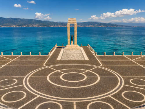 Strandpromenade mit geometrischem Mosaik-Design mit Blick auf das türkisfarbene Meer und die Berge, Reggio Calabria