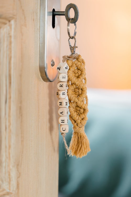Porte-clés en bois avec texte perlé « CHAMBRE 2 » et pompon macramé au Hameau de Céline B&B